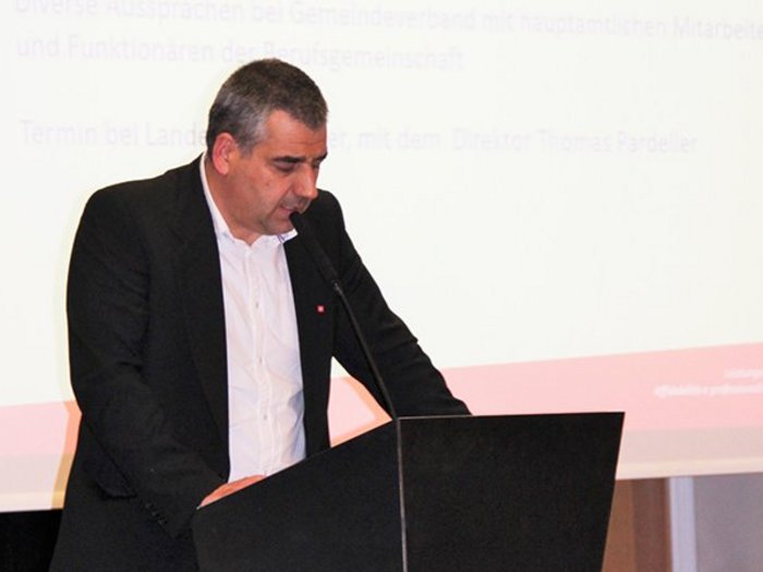 Mietwagenunternehmer: Auf Weissensteiner folgt Thaler Mann hält eine Rede am Rednerpult mit Projektionsleinwand im Hintergrund