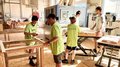 © lvh.apa Jugendliche und ein Erwachsener arbeiten an einer Holzwerkstatt mit Maschinen