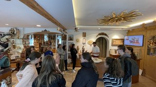 News Gruppe von Jugendlichen bei einer Führung durch einen Holzschnitzerei-Shop