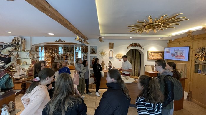 Entscheidung für den richtigen Beruf Gruppe von Jugendlichen bei einer Führung durch einen Holzschnitzerei-Shop