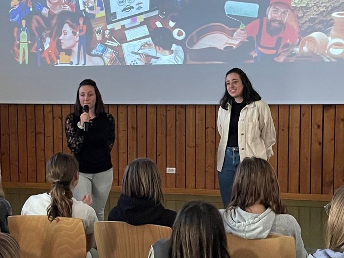 Coole Berufe im Handwerk und Gastgewerbe vorgestellt Zwei Frauen sprechen vor Jugendlichen bei einer Handwerkspräsentation mit Projektorwand