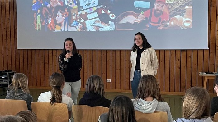 Coole Berufe im Handwerk und Gastgewerbe vorgestellt Zwei Frauen sprechen vor Jugendlichen bei einer Handwerkspräsentation mit Projektorwand