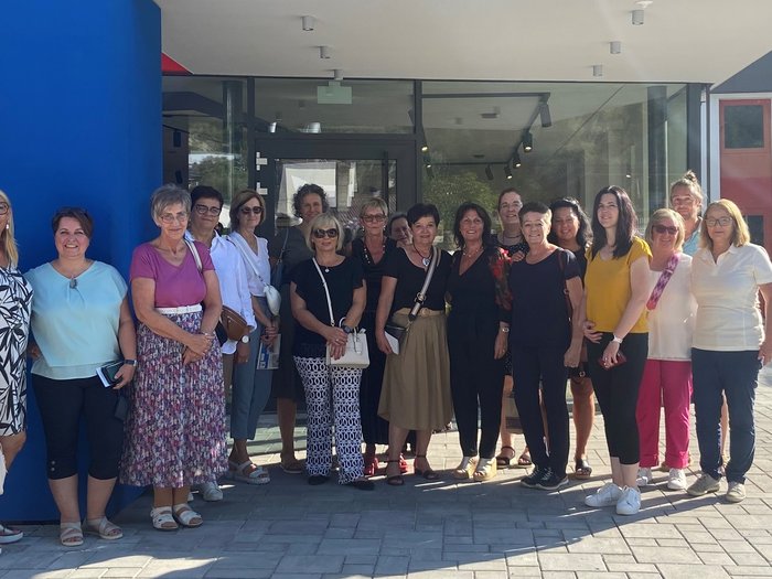 “Sostenibilità – anche oltre i confini” Gruppo di donne davanti all'edificio con il logo Schönthaler