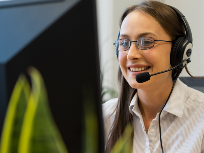 WIFO-Wirtschaftsbarometer Frühjahr 2024: gutes Geschäftsklima im Dienstleistungssektor, Ungewissheit im Güterverkehr Frau mit Brille und Headset arbeitet lächelnd am Computer