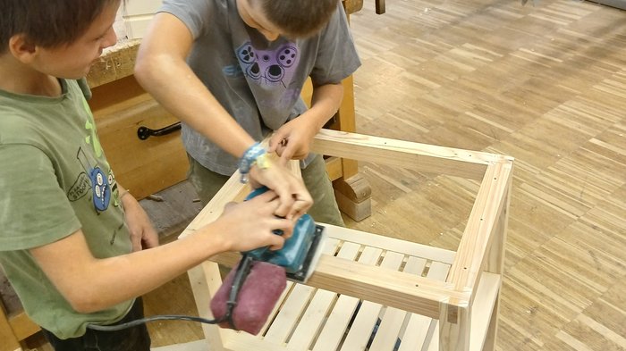 Mit Holz, Wasser & Handwerksfreude: Die KidsAcademy ist in Bruneck angekommen Zwei Jungen schleifen gemeinsam ein Holzstuhlgestell in einer Werkstatt