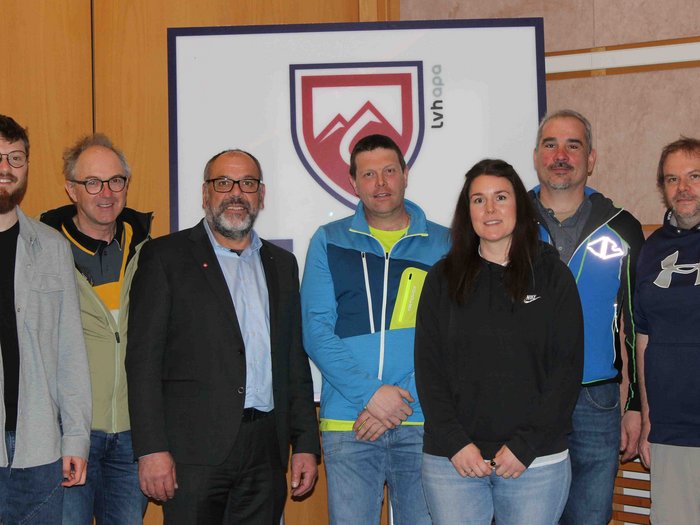 20 Jahre in der richtigen Spur Gruppenfoto von sieben Personen vor einem Schild mit Bergen und Schriftzug LVH apo