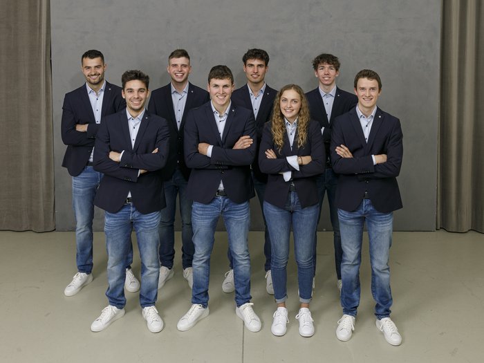 WorldSkills a Lione: presto il via! Gruppo di giovani adulti in jeans e blazer davanti a muro grigio