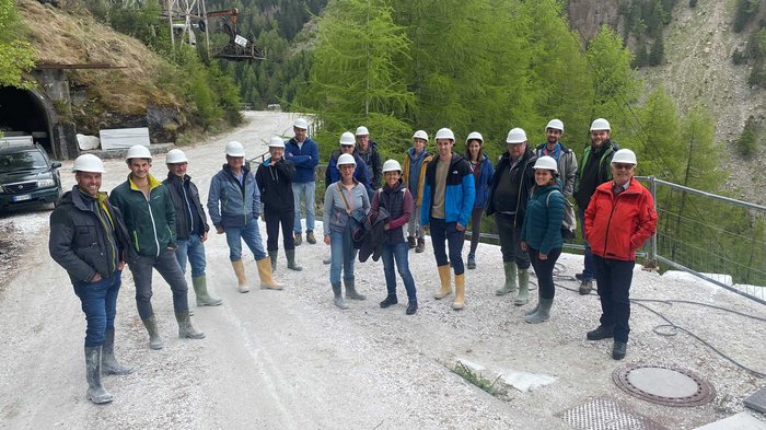 Ospiti della cava di “oro bianco” Gruppo di persone con caschi protettivi in zona mineraria montana