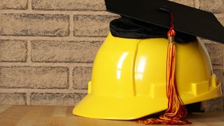 News Gelber Bauhelm mit akademischer Abschlusskappe und Quaste