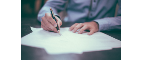 Sviluppo aziendale Mano che scrive con penna su foglio di carta su tavolo