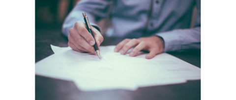 Sviluppo aziendale Mano che scrive con penna su foglio di carta su tavolo