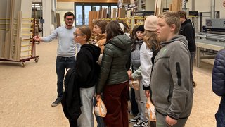News Gruppe von Jugendlichen bei einer Führung in einer Holzwerkstatt