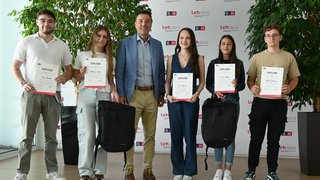 News Gruppe junger Menschen mit Diplomen und Rucksäcken vor LVH-Hintergrund