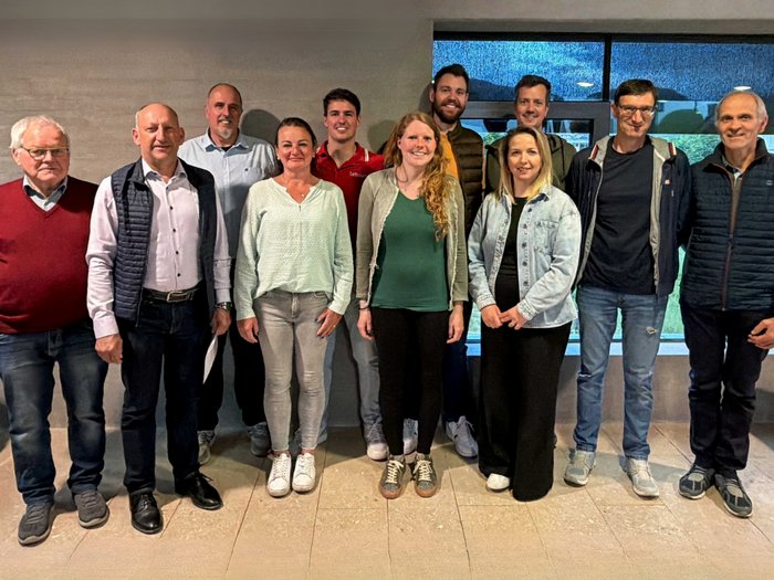 Un territorio mostra ciò che sa fare Foto di gruppo di undici persone davanti a una parete grigia all'interno