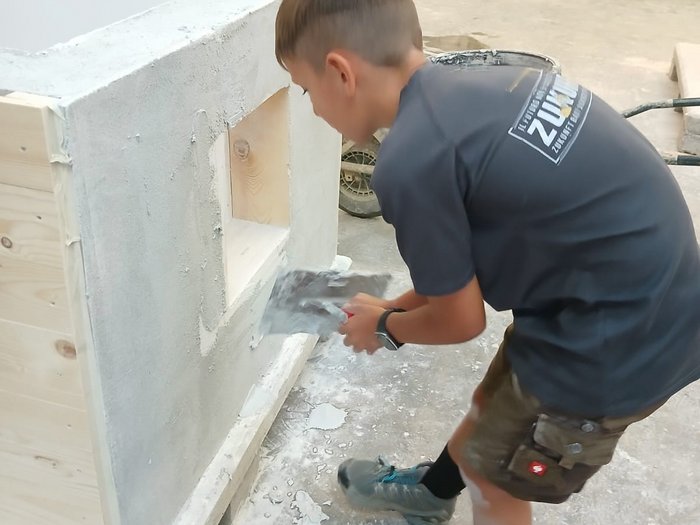 Handwerk zum Anfassen: KidsAcademy begeistert Kinder in Schlanders Junge arbeitet mit Kelle an einem Putzprojekt in einer Werkstatt