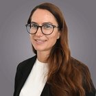 Meisterausbildung Porträt einer Frau mit langen braunen Haaren und Brille vor grauem Hintergrund