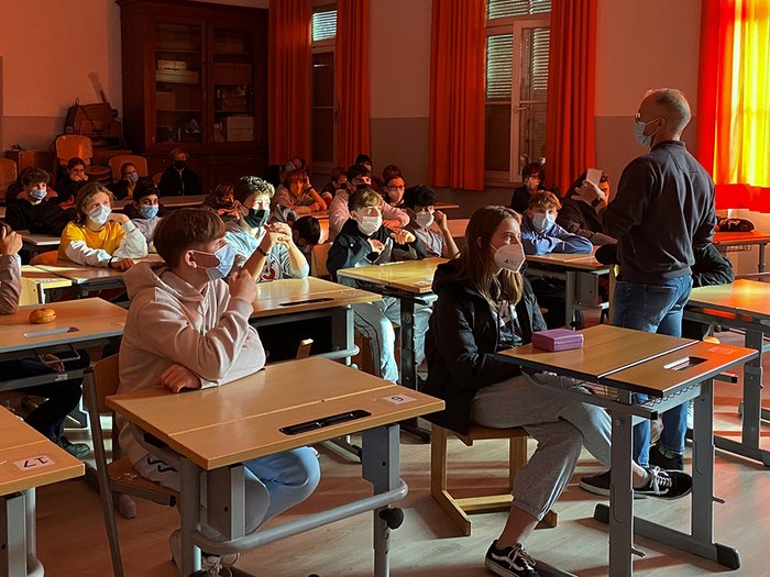 Junghandwerker im lvh und HGJ präsentieren praktische Berufe in Meran Klassenraum mit Schülern und Lehrer alle mit Gesichtsmasken während Unterricht