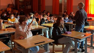 News Klassenraum mit Schülern und Lehrer alle mit Gesichtsmasken während Unterricht