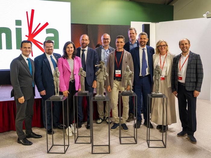 La 31^ Fiera d’Arte UNIKA apre le porte a Ortisei Foto di gruppo con dieci persone e cinque statue su piedistalli durante un evento