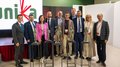 La 31^ Fiera d’Arte UNIKA apre le porte a Ortisei Foto di gruppo con dieci persone e cinque statue su piedistalli durante un evento