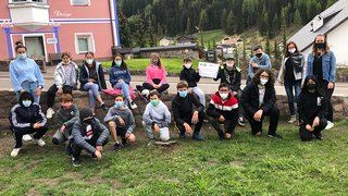 News Gruppe von Kindern und Jugendlichen trägt Masken im Freien vor Gebäuden im Grünen