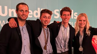 News Vier junge Erwachsene mit Medaillen bei einer Preisverleihung