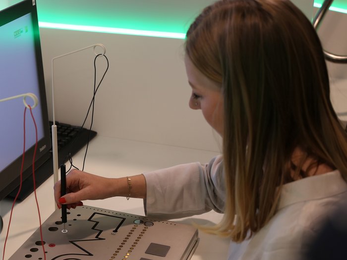 La delegazione altoatesina ha visitato il Talentcenter di Graz Donna utilizza un dispositivo di misurazione elettrica vicino a un computer in laboratorio