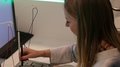 Südtiroler Delegation erkundete das Talentcenter in Graz Frau testet elektrisches Messgerät neben Computer in Laborumgebung