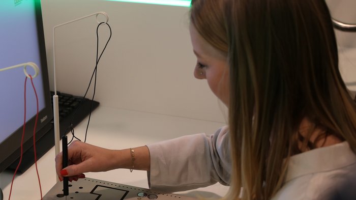 Südtiroler Delegation erkundete das Talentcenter in Graz Frau testet elektrisches Messgerät neben Computer in Laborumgebung
