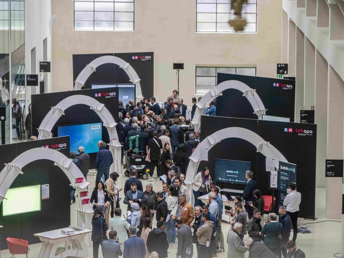 Intelligenza artigiana: nuove opportunità grazie all‘IA Visitatori a fiera o conferenza in edificio moderno con stand espositivi