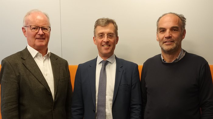 Pflichtversicherung gegen Naturkatastrophen – lvh erfreut über Aufschub Drei Männer stehen vor einer weißen Wand mit orangefarbenem Hintergrund