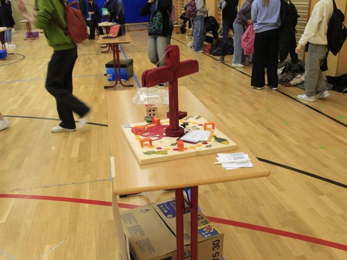 Kreative Spielideen: Preisverleihung für "Clever gebaut" Modell eines kleinen Krans auf einem Tisch in einer Turnhalle mit Schülerinnen und Schülern