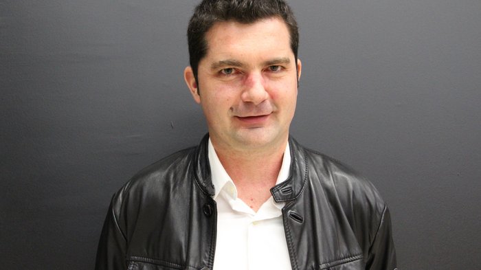 Integrazione salariale: il comparto edile è preoccupato Ritratto di uomo con giacca di pelle nera davanti a parete grigia