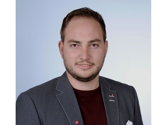 Michael Hofer, lvh-Obmann der Tiefbauunternehmer © lvh.apa Porträt eines lächelnden jungen Mannes mit Sakko vor hellem Hintergrund