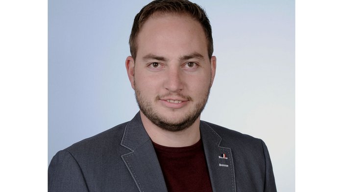 Michael Hofer, lvh-Obmann der Tiefbauunternehmer © lvh.apa Porträt eines lächelnden jungen Mannes mit Sakko vor hellem Hintergrund
