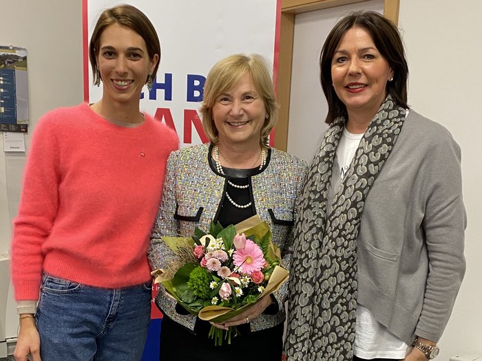 Duo femminile alla guida degli artigiani brissinesi Tre donne in piedi insieme, una tiene un mazzo di fiori in un ufficio