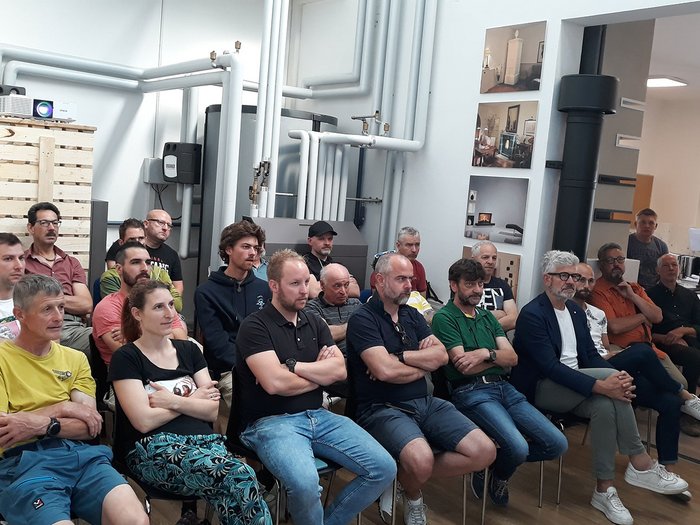 Jahresversammlung der Hafner im lvh – Foto: © lvh.apa Gruppe von Menschen sitzt aufmerksam in einem Raum mit vielen Rohren und Geräte