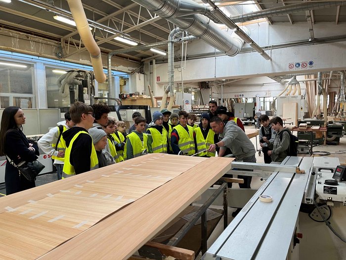 Alla scoperta del mondo dei mestieri a Rio di Pusteria Gruppo di bambini con giubbotti di sicurezza in una falegnameria durante una visita guidata