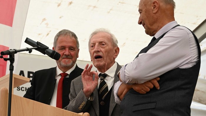 61° incontro degli artigiani anziani a Lutago: un'esperienza indimenticabile Tre uomini anziani parlano a un evento davanti al microfono