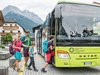 Home Famiglia sale su autobus verde in città di montagna con case tradizionali