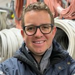 Unterpustertal/Gadertal Porträt eines lächelnden Mannes mit Brille vor Kabelrollen