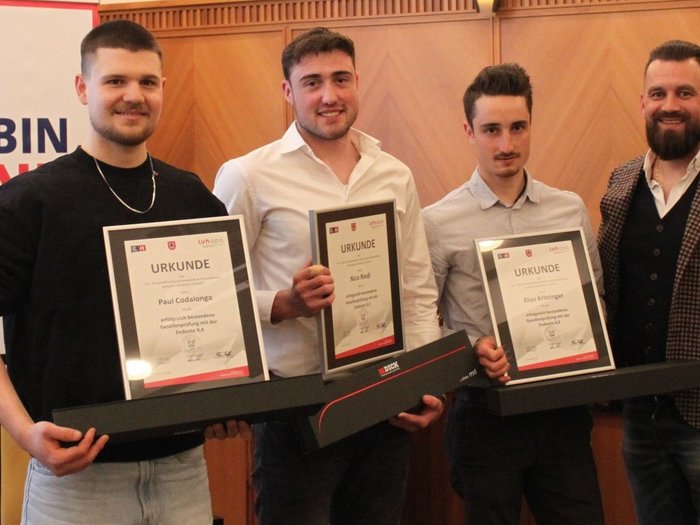 Fieri dell'artigianato e del futuro: i macellai altoatesini celebrano la loro professione, i giovani talenti e la qualità Tre uomini con certificati e una quarta persona in abbigliamento formale
