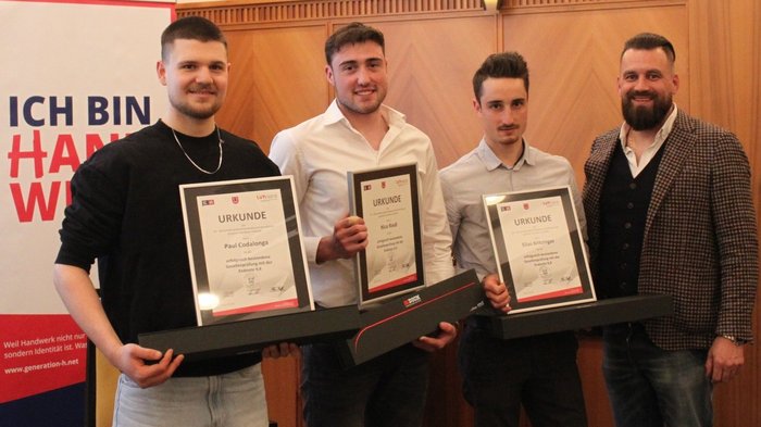 Fieri dell'artigianato e del futuro: i macellai altoatesini celebrano la loro professione, i giovani talenti e la qualità Tre uomini con certificati e una quarta persona in abbigliamento formale