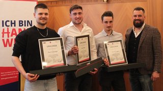 News Tre uomini con certificati e una quarta persona in abbigliamento formale