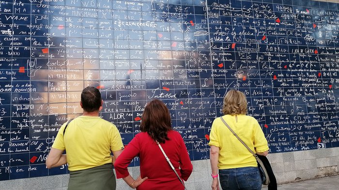 lvh-Seniorinnen und Senioren auf Frühlingsreise: Paris, mon amour! Drei Personen betrachten eine blaue Wand mit verschiedenen handschriftlichen Botschaften