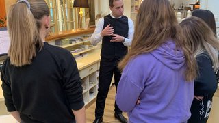 News Hotelmitarbeiter erklärt einer Gruppe junger Gäste die Abläufe an der Rezeption