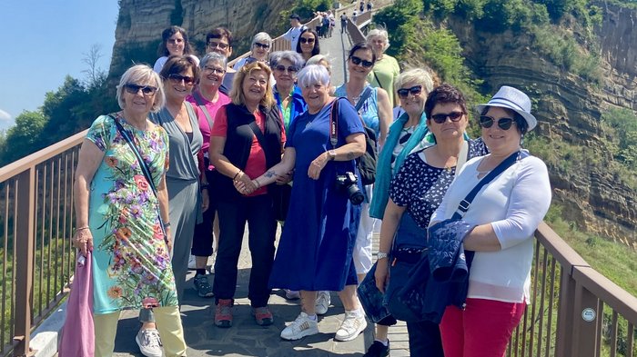 Frauen im Handwerk auf Entdeckungstour Gruppe von Frauen auf einer Brücke vor einer alten Bergfestung bei sonnigem Wetter