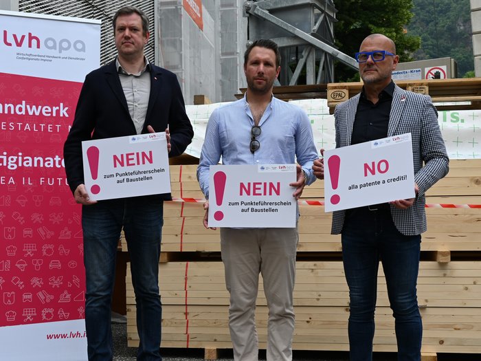 Punkteführerschein kein wirksames Mittel zur Gewährung der Arbeitssicherheit Drei Männer halten Schilder mit Nein zum Punkteführerschein auf Baustellen