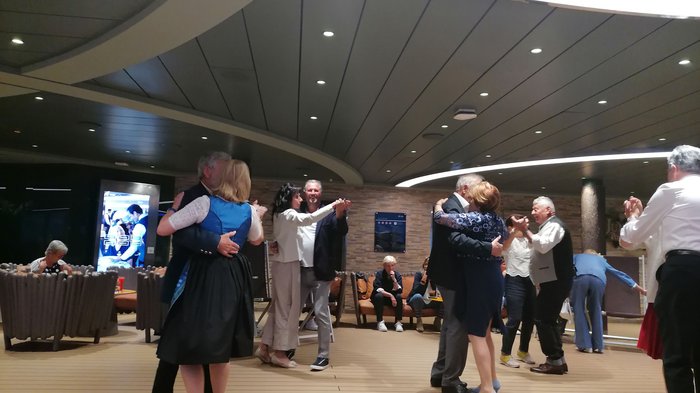 Artigiani anziani in crociera Coppie di anziani ballano in una sala moderna illuminata