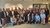 Gruppo di uomini e donne posa per una foto in un ambiente interno
